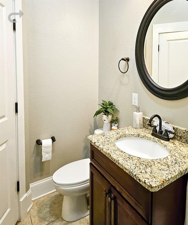 bathroom with tile patterned flooring, vanity, and toilet