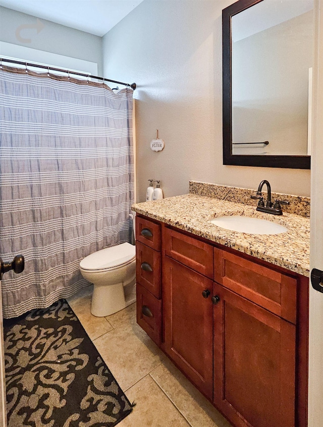 bathroom featuring vanity, tile patterned floors, and toilet