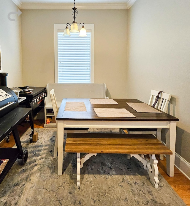 dining room featuring ornamental molding, wood-type flooring, and a chandelier