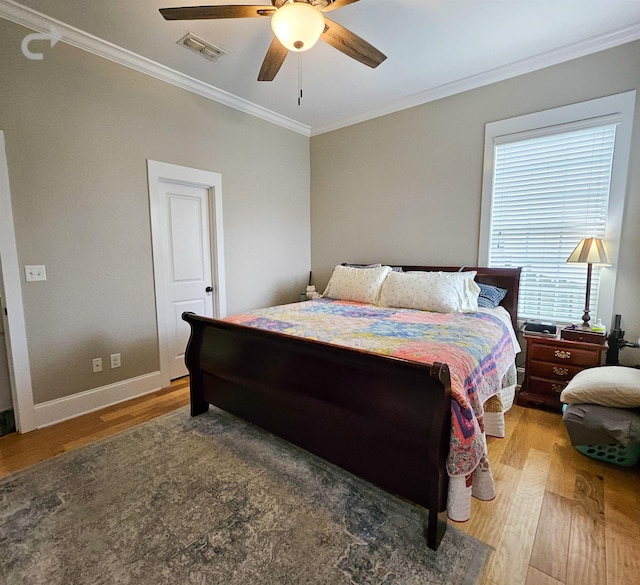 bedroom with ornamental molding, wood-type flooring, and ceiling fan