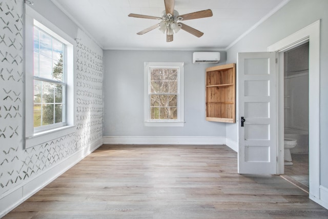 interior space with wallpapered walls, baseboards, a wall unit AC, ornamental molding, and wood finished floors