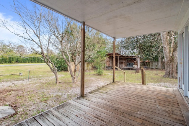 wooden terrace featuring fence and a yard