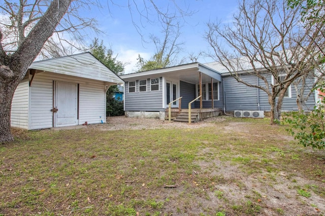 back of property featuring an outbuilding, covered porch, a lawn, and a storage shed