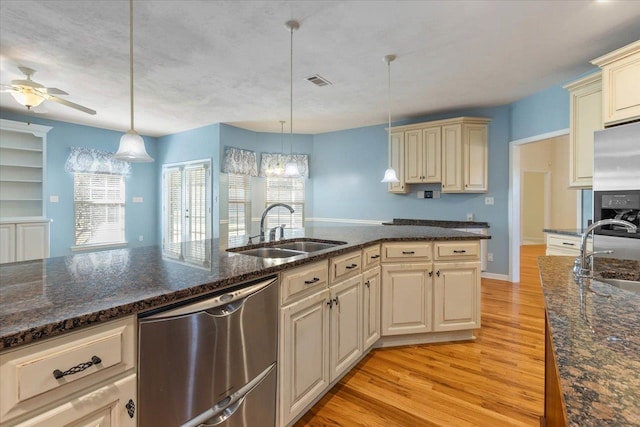 kitchen featuring sink, stainless steel appliances, and decorative light fixtures