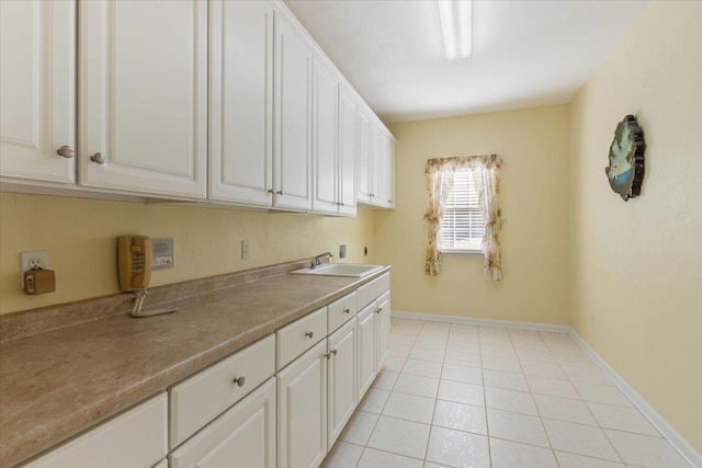 laundry area featuring sink, cabinets, hookup for a washing machine, and light tile patterned floors