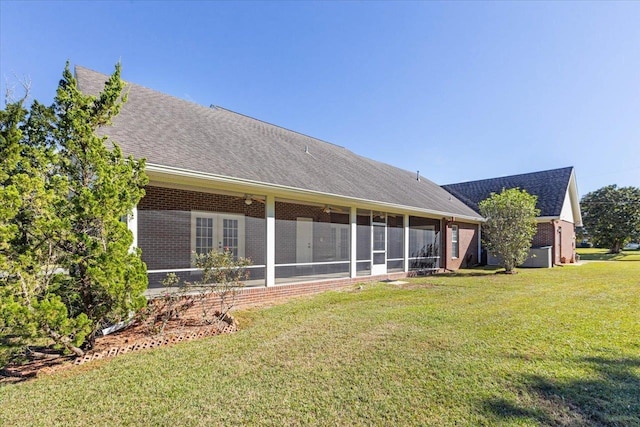 rear view of property with a sunroom and a lawn