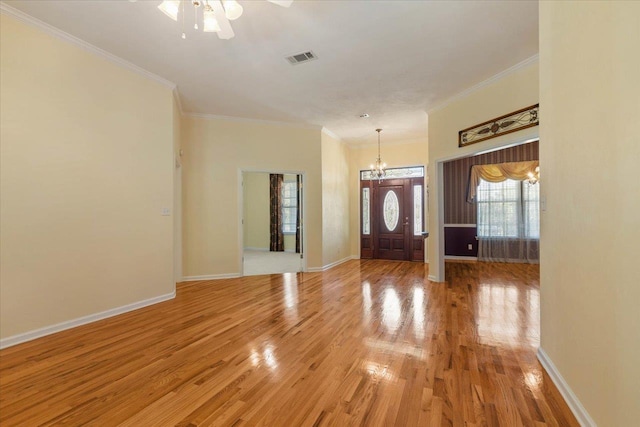 foyer entrance featuring ornamental molding, hardwood / wood-style flooring, and ceiling fan with notable chandelier