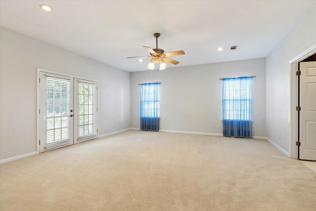 carpeted empty room with plenty of natural light, ceiling fan, and french doors