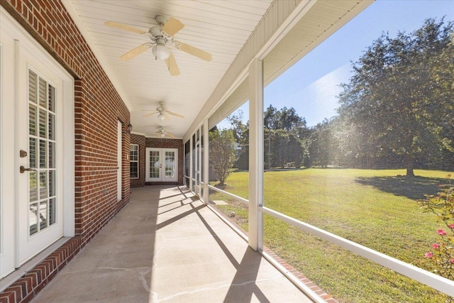 unfurnished sunroom featuring ceiling fan