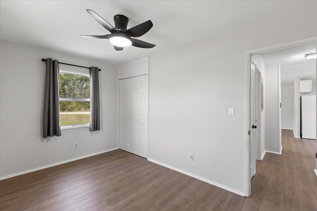 603 W Ash St, Perry, FL 32347 - unfurnished bedroom featuring white fridge, wood finished floors, baseboards, and a closet