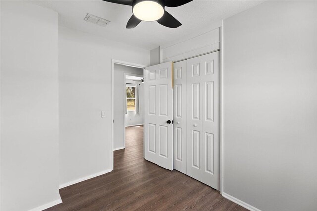 603 W Ash St, Perry, FL 32347 - unfurnished bedroom with baseboards, dark wood-type flooring, a closet, and a ceiling fan