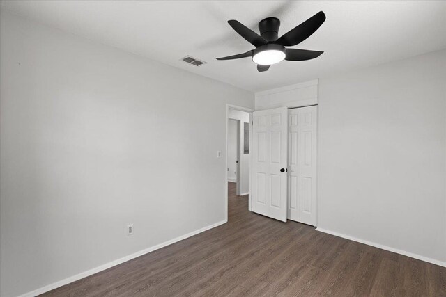 603 W Ash St, Perry, FL 32347 - unfurnished bedroom with dark wood-style floors, baseboards, a closet, and a ceiling fan