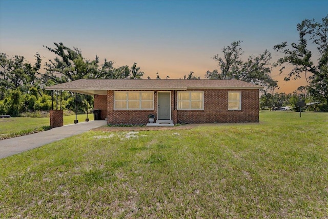 603 W Ash St, Perry, FL 32347 - ranch-style house featuring concrete driveway, brick siding, a lawn, and a carport