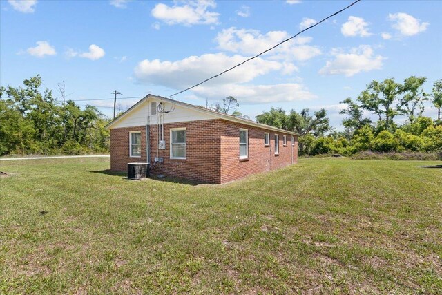 603 W Ash St, Perry, FL 32347 - view of property exterior featuring brick siding, a lawn, and cooling unit