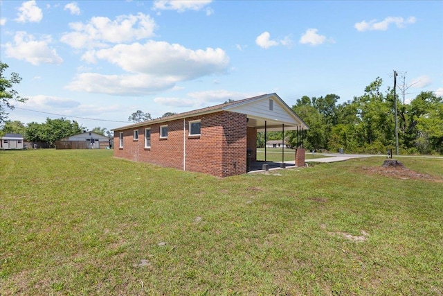 603 W Ash St, Perry, FL 32347 - view of side of home with an attached carport, a lawn, and brick siding