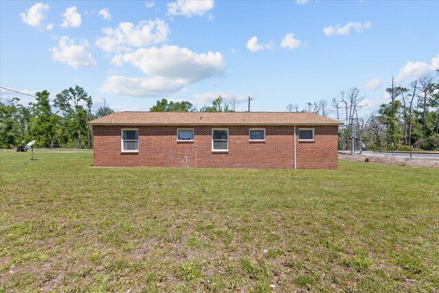 603 W Ash St, Perry, FL 32347 - view of property exterior featuring a lawn and brick siding