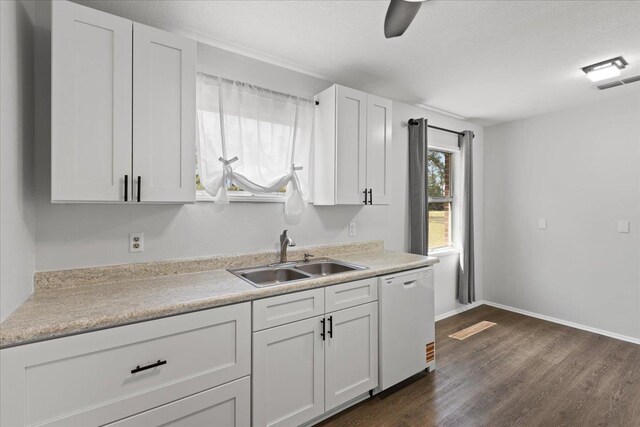 603 W Ash St, Perry, FL 32347 - kitchen featuring dishwasher, a sink, dark wood-style floors, white cabinetry, and light countertops