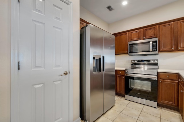 1320 Hendrix Rd Unit 403, Tallahassee, FL 32301 - kitchen featuring stainless steel appliances, light tile patterned floors, light countertops, brown cabinetry, and recessed lighting