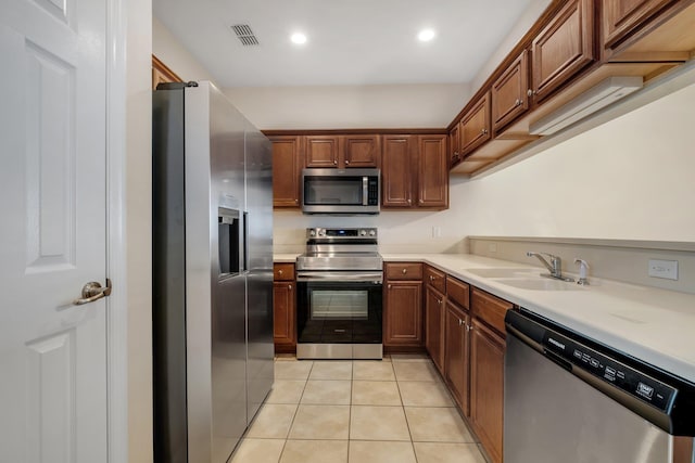 1320 Hendrix Rd Unit 403, Tallahassee, FL 32301 - kitchen featuring appliances with stainless steel finishes, light countertops, light tile patterned floors, recessed lighting, and brown cabinetry