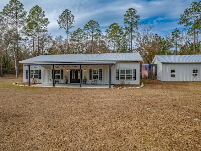 rear view of property featuring a yard and a patio