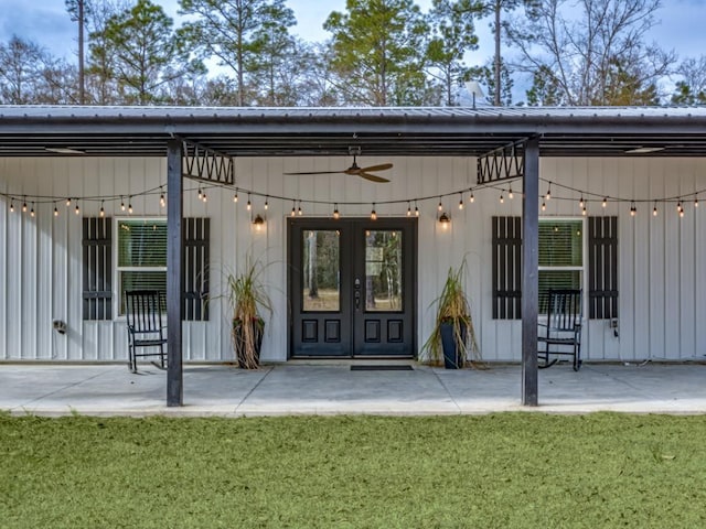 entrance to property featuring a patio area, ceiling fan, and a lawn