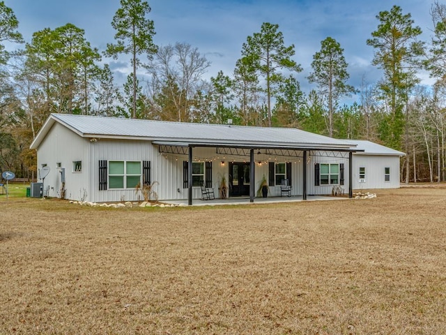 rear view of house featuring cooling unit, a yard, and a patio area