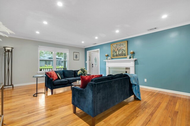 living area featuring crown molding, recessed lighting, light wood finished floors, a tile fireplace, and baseboards