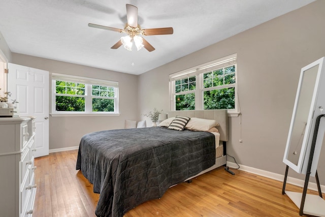bedroom with baseboards, light wood-type flooring, and ceiling fan