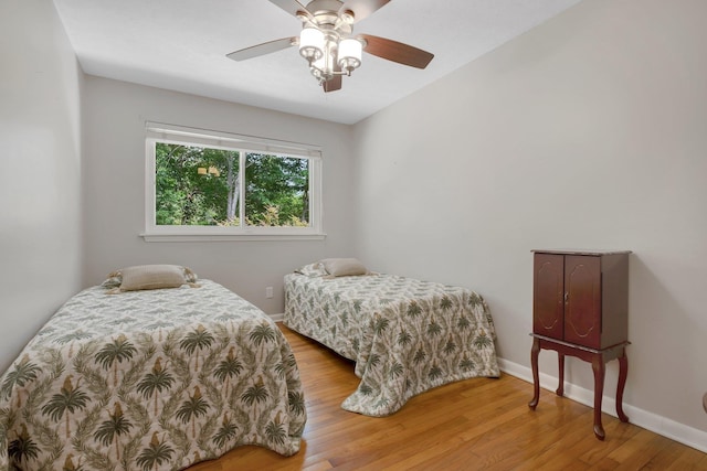 bedroom with wood finished floors, baseboards, and ceiling fan