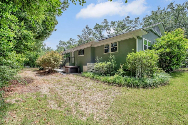 view of side of home featuring stucco siding and a lawn