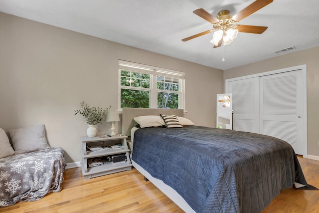 bedroom featuring wood finished floors, a closet, baseboards, and a ceiling fan