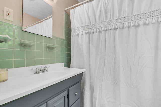 bathroom with tile walls, vanity, and a shower with shower curtain