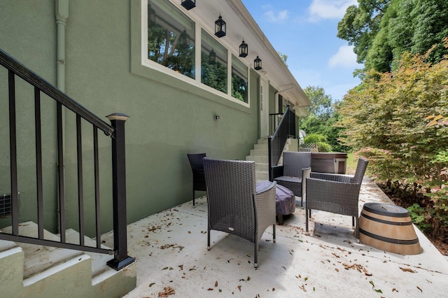 view of patio / terrace with a hot tub and stairway