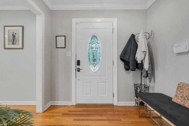 entryway with light wood-style floors, baseboards, and ornamental molding