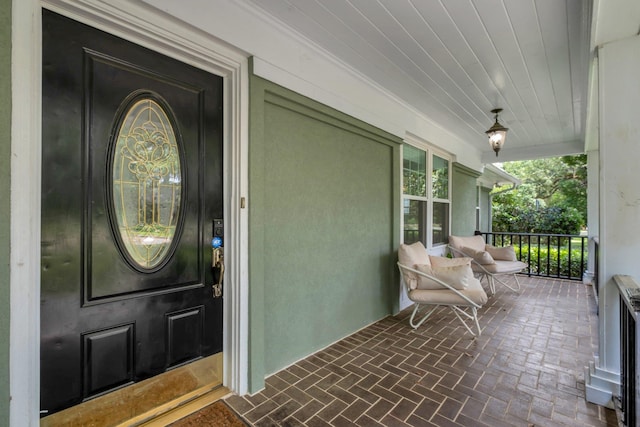 property entrance featuring covered porch and stucco siding