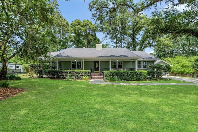 single story home featuring a porch, a front yard, and a chimney