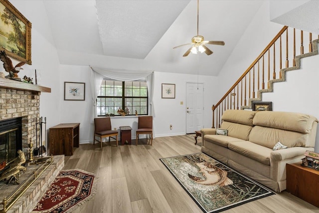 living room with ceiling fan, lofted ceiling, light hardwood / wood-style floors, and a fireplace