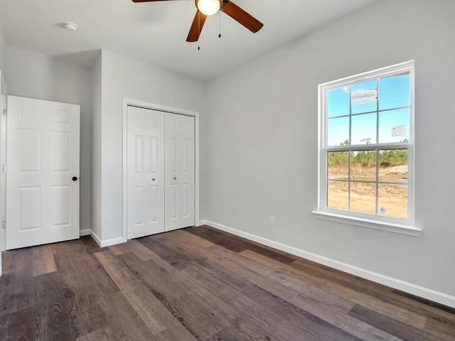 unfurnished bedroom with a closet, ceiling fan, and dark wood-type flooring