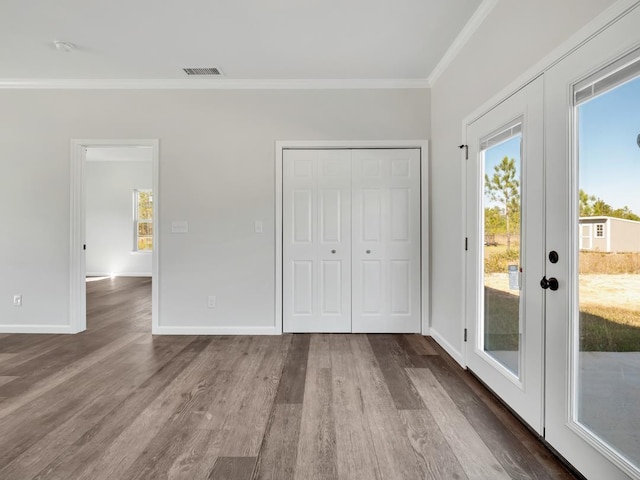 interior space with access to outside, french doors, ornamental molding, wood-type flooring, and a closet