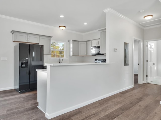 kitchen with black appliances, gray cabinetry, kitchen peninsula, and hardwood / wood-style floors