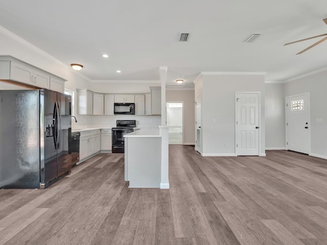 kitchen with a center island, black appliances, gray cabinets, ornamental molding, and light hardwood / wood-style floors