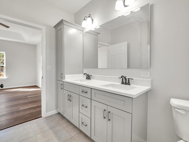 bathroom with ceiling fan, hardwood / wood-style floors, vanity, and toilet