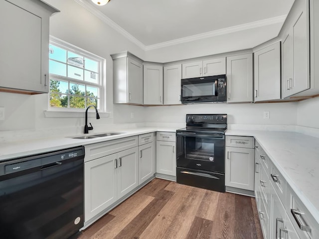 kitchen with gray cabinetry, sink, dark wood-type flooring, black appliances, and ornamental molding