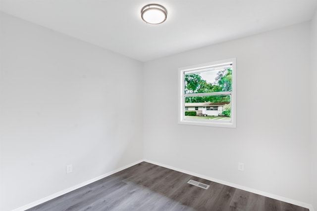 unfurnished room with dark wood finished floors, baseboards, and visible vents