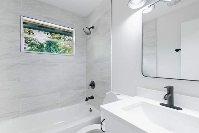 bathroom featuring toilet, vanity, visible vents, and bathing tub / shower combination