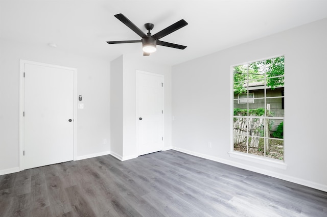 unfurnished room with wood finished floors, baseboards, and ceiling fan