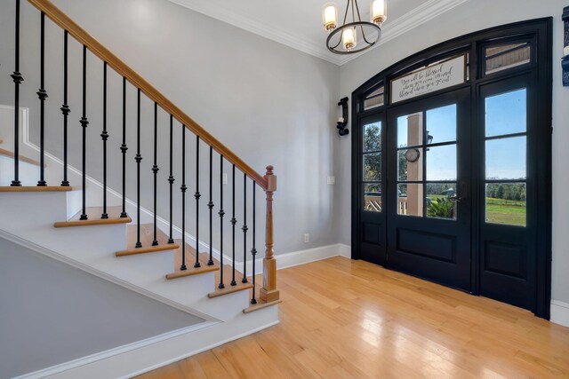 1165 Dills Rd, Monticello, FL 32344 - foyer entrance featuring wood finished floors, a chandelier, baseboards, crown molding, and stairs
