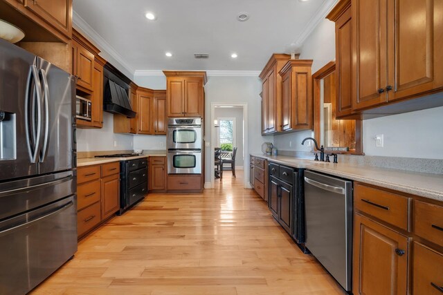 1165 Dills Rd, Monticello, FL 32344 - kitchen featuring stainless steel appliances, ornamental molding, premium range hood, light wood finished floors, and a sink