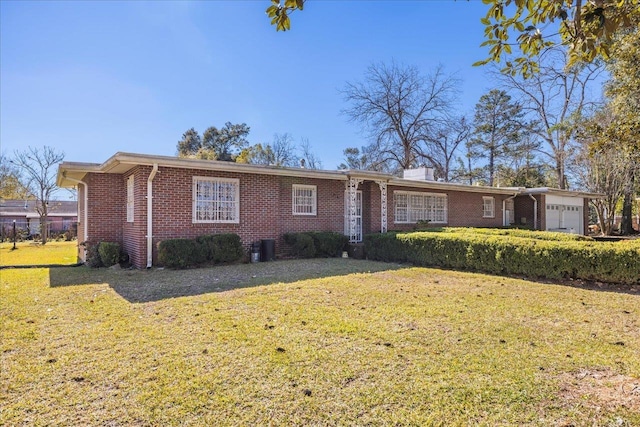 ranch-style home featuring brick siding, an attached garage, and a front yard