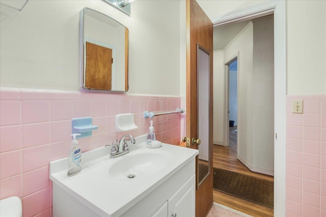 bathroom featuring wainscoting, vanity, and tile walls